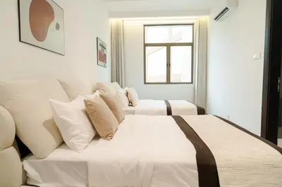 a white bedroom with two beds and a window at Georgetown Bright & Kid-Friendly KTV 3BR 15pax C in George Town