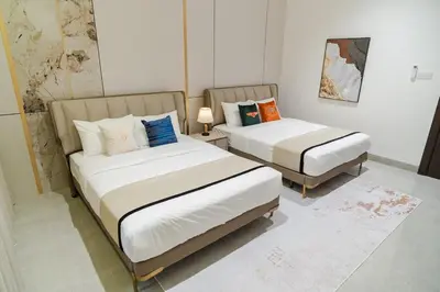 two beds in a small room with two lamps at Georgetown Elegant Golden Jacuzzi KTV 5BR 16pax E in George Town