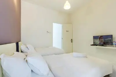 a bedroom with two beds with white pillows at 2a\u8c6a\u534e\u4e09\u5c42\u6392\u5c4b6\u623f6\u6d74\u5ba4\u5bb6\u5ead\u805a\u4f1a\u7ed3\u5a5a\u751f\u65e5USM\u69df\u5a01\u5927\u6865SPICE\u4f1a\u5c55\u4e2d\u5fc3\u4e54\u6cbb\u5e02 in Gelugor