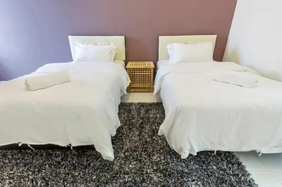 two beds with white sheets in a room at 2a\u8c6a\u534e\u4e09\u5c42\u6392\u5c4b6\u623f6\u6d74\u5ba4\u5bb6\u5ead\u805a\u4f1a\u7ed3\u5a5a\u751f\u65e5USM\u69df\u5a01\u5927\u6865SPICE\u4f1a\u5c55\u4e2d\u5fc3\u4e54\u6cbb\u5e02 in Gelugor