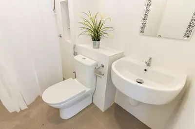 a white bathroom with a toilet and a sink at 2a\u8c6a\u534e\u4e09\u5c42\u6392\u5c4b6\u623f6\u6d74\u5ba4\u5bb6\u5ead\u805a\u4f1a\u7ed3\u5a5a\u751f\u65e5USM\u69df\u5a01\u5927\u6865SPICE\u4f1a\u5c55\u4e2d\u5fc3\u4e54\u6cbb\u5e02 in Gelugor