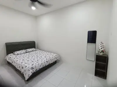 a white room with a bed and a tv at Aleesa Homestay in Tapah