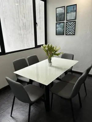 a white table with chairs and a vase with flowers at Spacious 4BR Family Suites in George Town in George Town