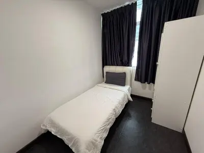 a small bed in a small room with a window at Spacious 4BR Family Suites in George Town in George Town
