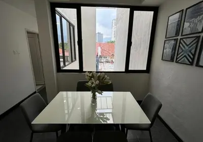 a dining room table with a vase of flowers on it at Spacious 4BR Family Suites in George Town in George Town