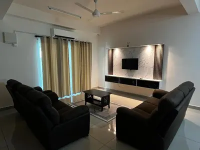a living room with two couches and a flat screen tv at Homestay Adyana in Raub
