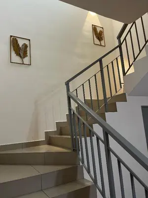 a staircase in a house with two pictures on the wall at Homestay Adyana in Raub