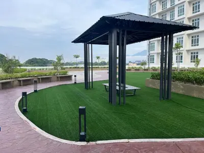a pavilion with a bench on a lawn in front of a building at The Anderson Ipoh AA4 7pax, Smart TV & Wi-Fi in Ipoh