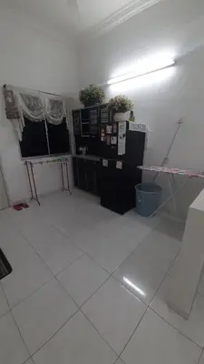 a room with a white tiled floor and black cabinets at Glory Homestay Ipoh in Ipoh