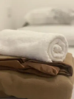 a white towel is sitting on top of towels at Heritage House 123 in George Town