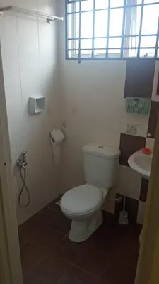 a bathroom with a white toilet and a sink at Dynamic homes stay in Ipoh