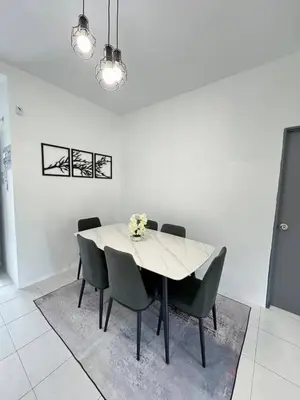 a dining room with a white table and chairs at Eisya Homestay 2 at Emerald Avenue Brinchang in Brinchang