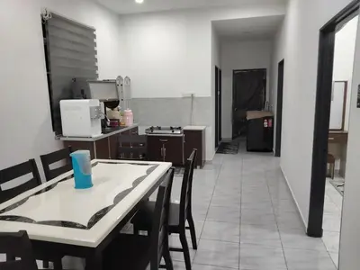 a kitchen with a table and chairs in a room at Tasmie homestay in Butterworth