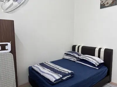a bedroom with a bed with blue sheets and pillows at Rafeeqs Homestay in Teluk Intan