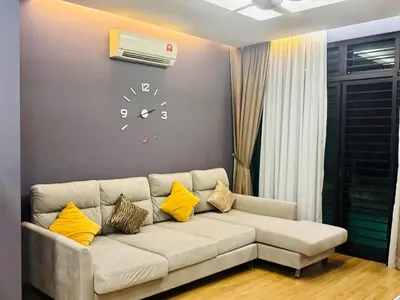 a living room with a couch and a clock on the wall at Charming Luxury Villa 20,BBQ, Close to Beach Shops in Batu Ferringhi