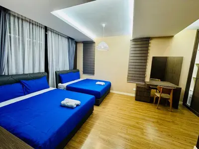 a bedroom with two blue beds and a television at Charming Luxury Villa 20,BBQ, Close to Beach Shops in Batu Ferringhi