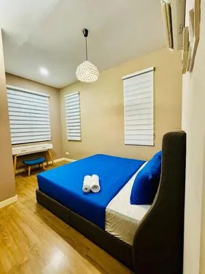 a bedroom with a blue bed with two towels on it at Charming Luxury Villa 20,BBQ, Close to Beach Shops in Batu Ferringhi