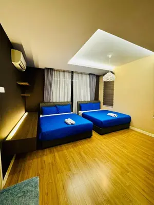 two beds in a room with blue pillows at Beautiful 20-Person Villa, Walk to Beach & Market in Batu Ferringhi