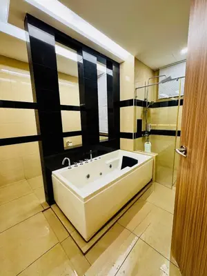 a bathroom with a large white bath tub next to a shower at Beautiful 20-Person Villa, Walk to Beach & Market in Batu Ferringhi