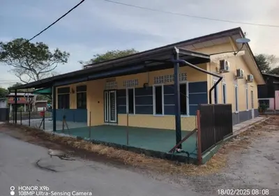a yellow and blue building with a gate in front of it at Homestay Zainab Sg Dua Mslim With 100mbps Wifi in Kepala Batas
