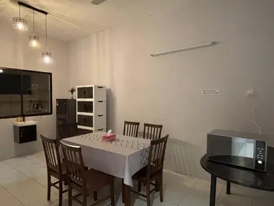 a dining room with a table and chairs and a television at Comfy21 Homestay Tambun, Ipoh in Ipoh
