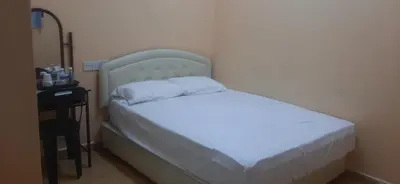 a small bed in a room with a night stand at Wonderful Motel in Taiping