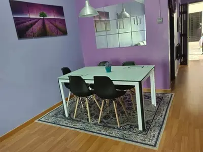 a dining room table with black chairs and a purple wall at Zaca's Rents in Kampong Duson Gilap