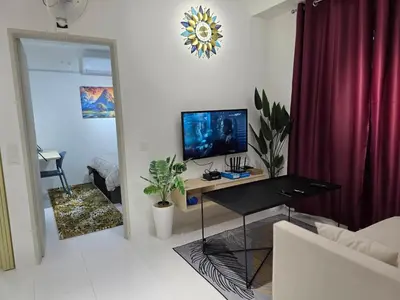 a living room with a desk with a television on it at Nature Beauty Homestay in Seri Iskandar