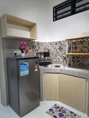 a kitchen with a refrigerator and a sink at Nature Beauty Homestay in Seri Iskandar