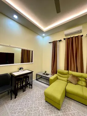 a living room with a green couch and a table at dayah homestay in Siputih
