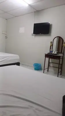 a room with a bed and a tv on a wall at Wonderful Motel in Taiping