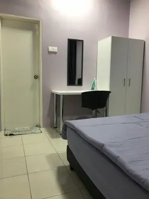 a bedroom with a bed and a desk and a table at VS Homestay in Ipoh