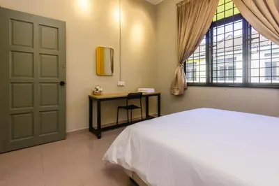a bedroom with a bed and a table and a window at 13-Pax Vacation Retreats in Butterworth near Sunway Carnival in Perai