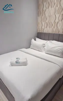 a bed with white sheets and towels on it at Iconic Regency by BNB4U in Bayan Lepas