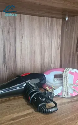 a hair dryer sitting on top of a wooden table at Iconic Regency by BNB4U in Bayan Lepas