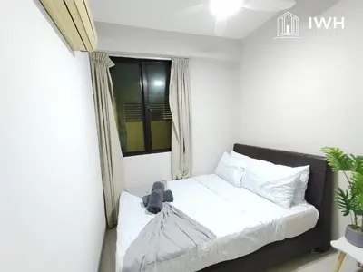 a bedroom with a bed with a teddy bear on it at Kinta River Town Suites By IWH in Ipoh