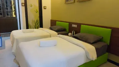 three beds in a room with green and white at D GAYA HOTEL Cameron Highlands in Tanah Rata