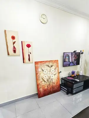 a room with a clock on a wall with a painting at Venice Manjung, Lumut by TZ Homestay in Lumut