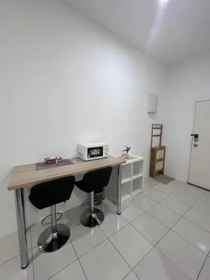 a kitchen with a table with two chairs and a microwave at CT Hillcrest Loft Ipoh in Ipoh