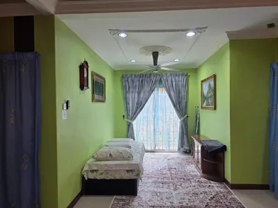 a bedroom with green walls and a window with two beds at Permata Atiey Homestay in Seri Iskandar