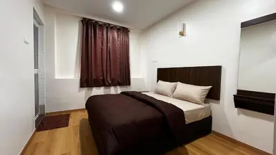 a bedroom with a bed and a window at Skye Apartment Hotel in Brinchang