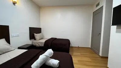 a room with two beds with white towels on them at Skye Apartment Hotel in Brinchang