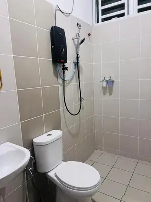 a bathroom with a shower with a toilet and a sink at Lunas Indah Homestay in Lunas