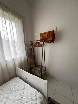 a small bedroom with a bed and a window at Lily Dante in Tanah Rata