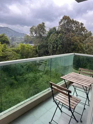 a balcony with a bench and a table on a balcony at Lily Dante in Tanah Rata