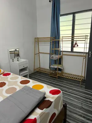 a bedroom with a bed and a desk and a window at CK Homestay Parit Buntar Perak in Bagan Serai