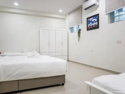 a white bedroom with two beds and a mirror at Wishful Guesthouse at Georgetown#LohGuanLye#BudgetStay in George Town