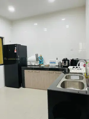 a kitchen with a sink and a black refrigerator at Sofea Homestay Ipoh V2 in Ipoh