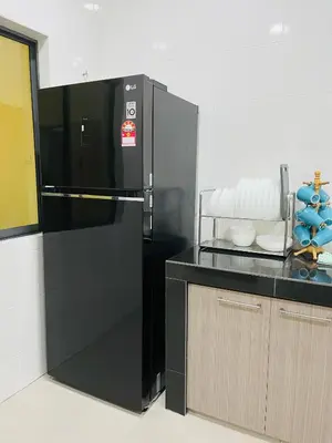 a black refrigerator in a kitchen next to a counter at Sofea Homestay Ipoh V2 in Ipoh