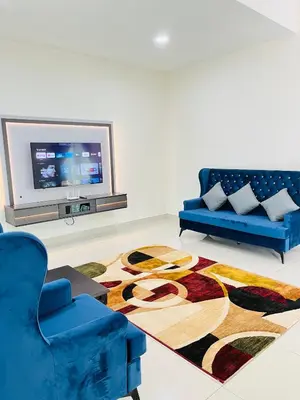 a living room with a blue couch and a rug at Sofea Homestay Ipoh V2 in Ipoh